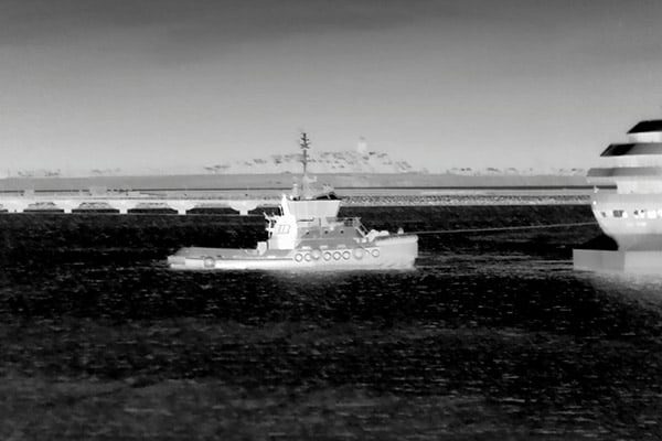 Image thermique d'un bateau remorqueur conduisant un navire de croisière